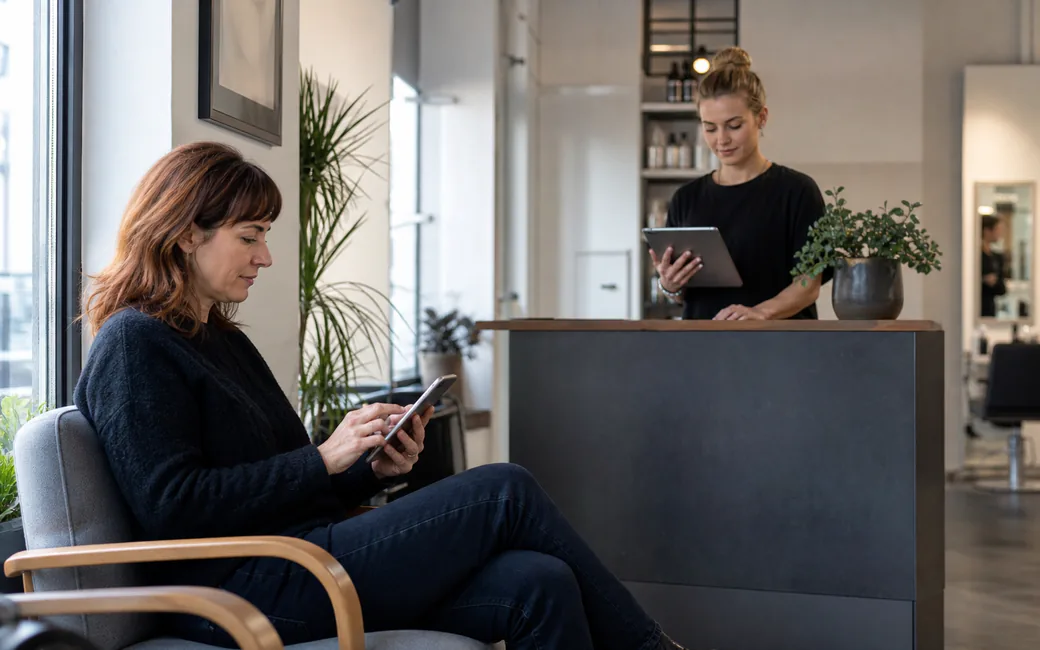 Praxisnahe Arbeitssituation zu Online-Buchung im Salon: Telefon, Empfang und digitale Termine in einem System verbinden in einem modernen deutschen Salon